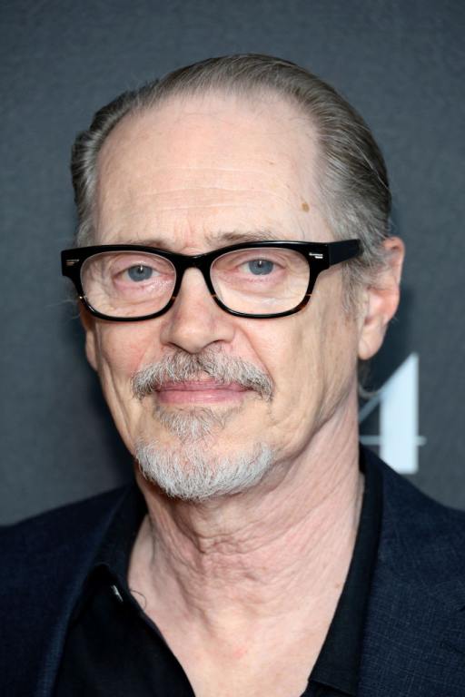 Steve Buscemi attends the "You Hurt My Feelings" New York Screening smiling wearing black framed glasses and a black shirt.