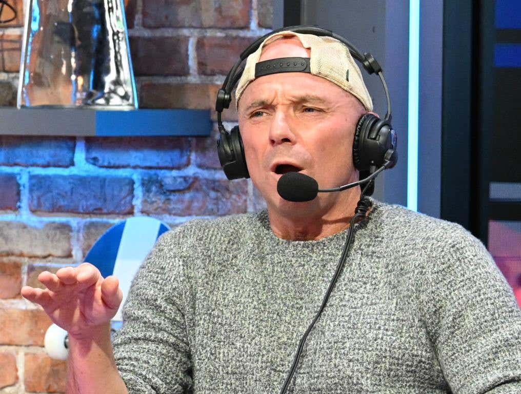 Kenny Chesney is wearing headphones and a gray sweater.